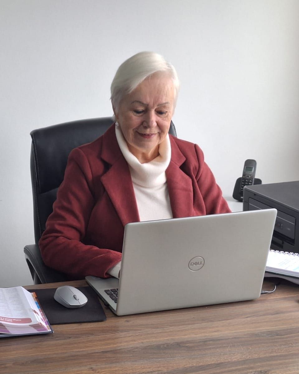 Dra. Soeli Konell sorrindo à mesa de atendimento do escritório de advocacia em Joinville