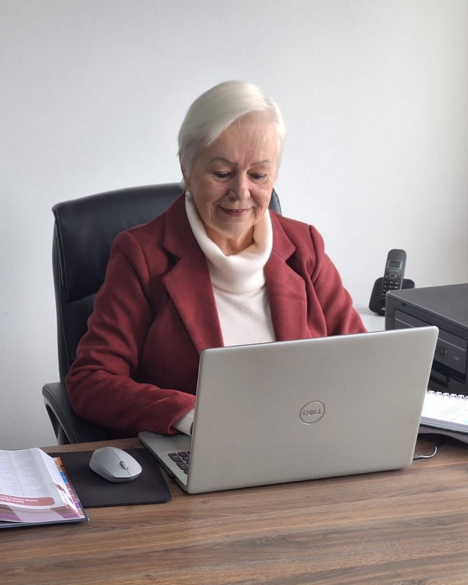 Dra. Soeli Konell trabalha ao notebook na mesa do escritório em Joinville