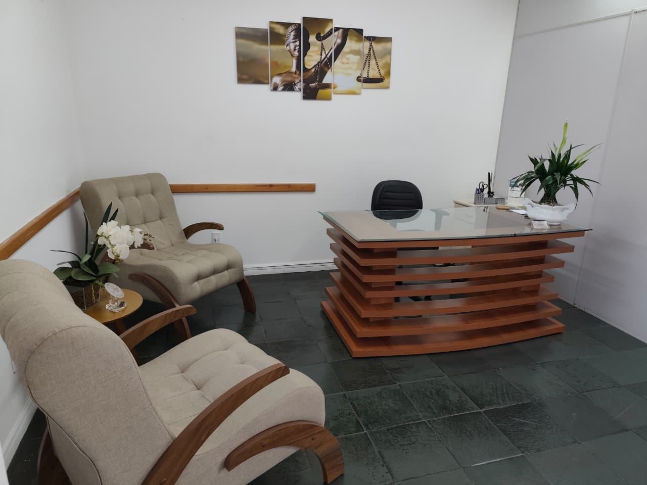 Recepção do escritório da Dra. Soeli Konell no Centro de Joinville, com poltronas e mesa de madeira