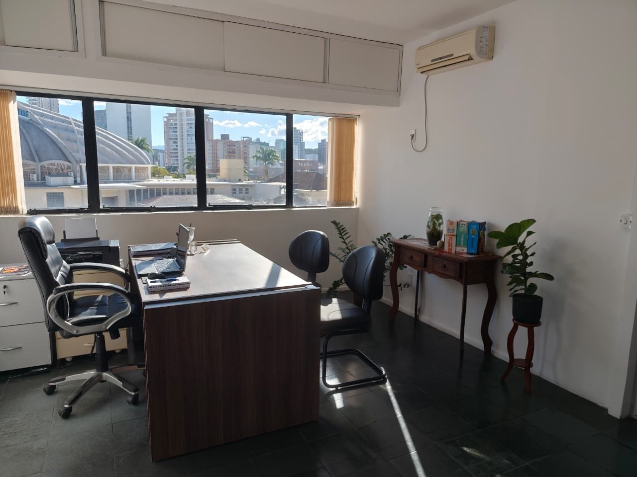 Mesa e cadeiras onde a Dra. Soeli Konell recebe os clientes, com a janela em contraluz