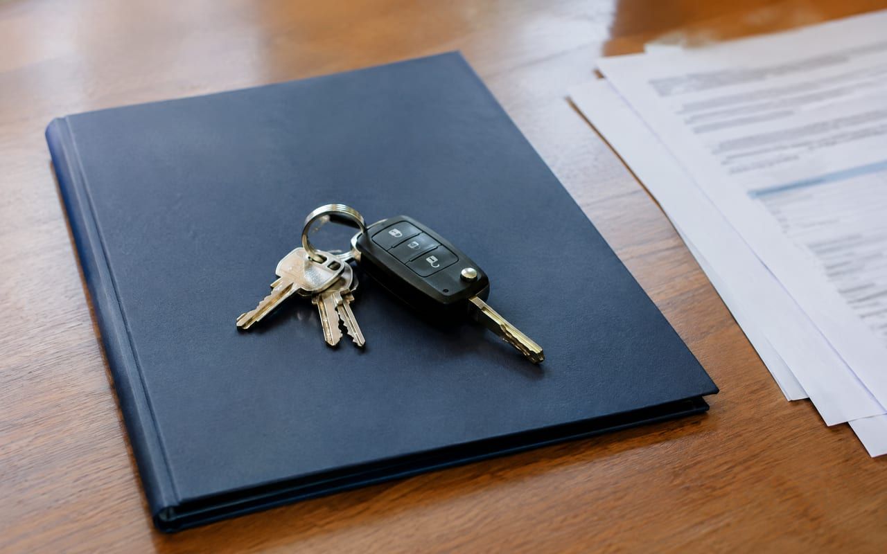 Chaves de casa e de carro ao lado de uma pasta com os documentos dos bens da herança